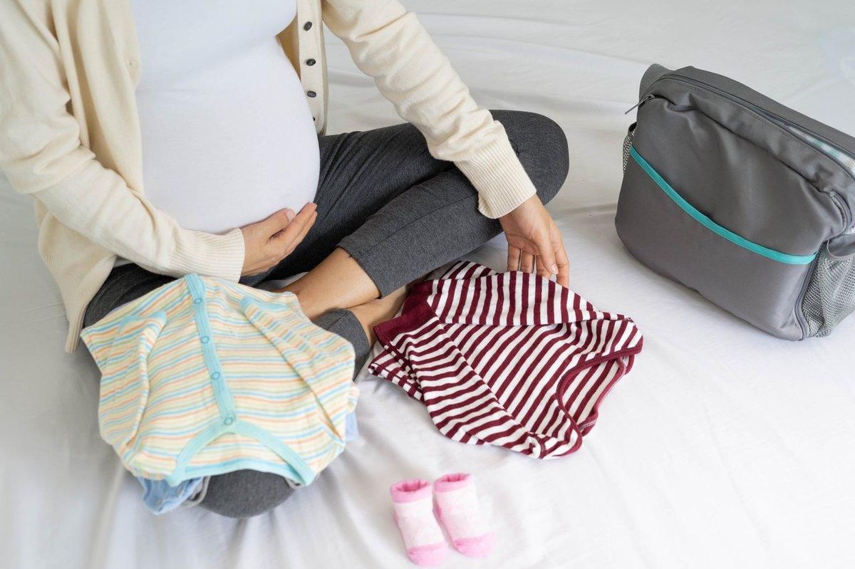 Valise maternité organisée avec vêtements amples pour une césarienne programmée, prête pour l'hospitalisation.